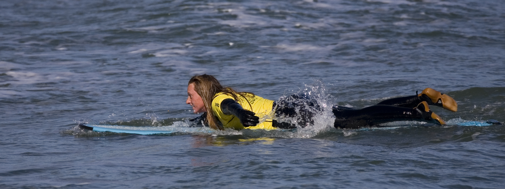 a dog lays on the surfboard in the ocean