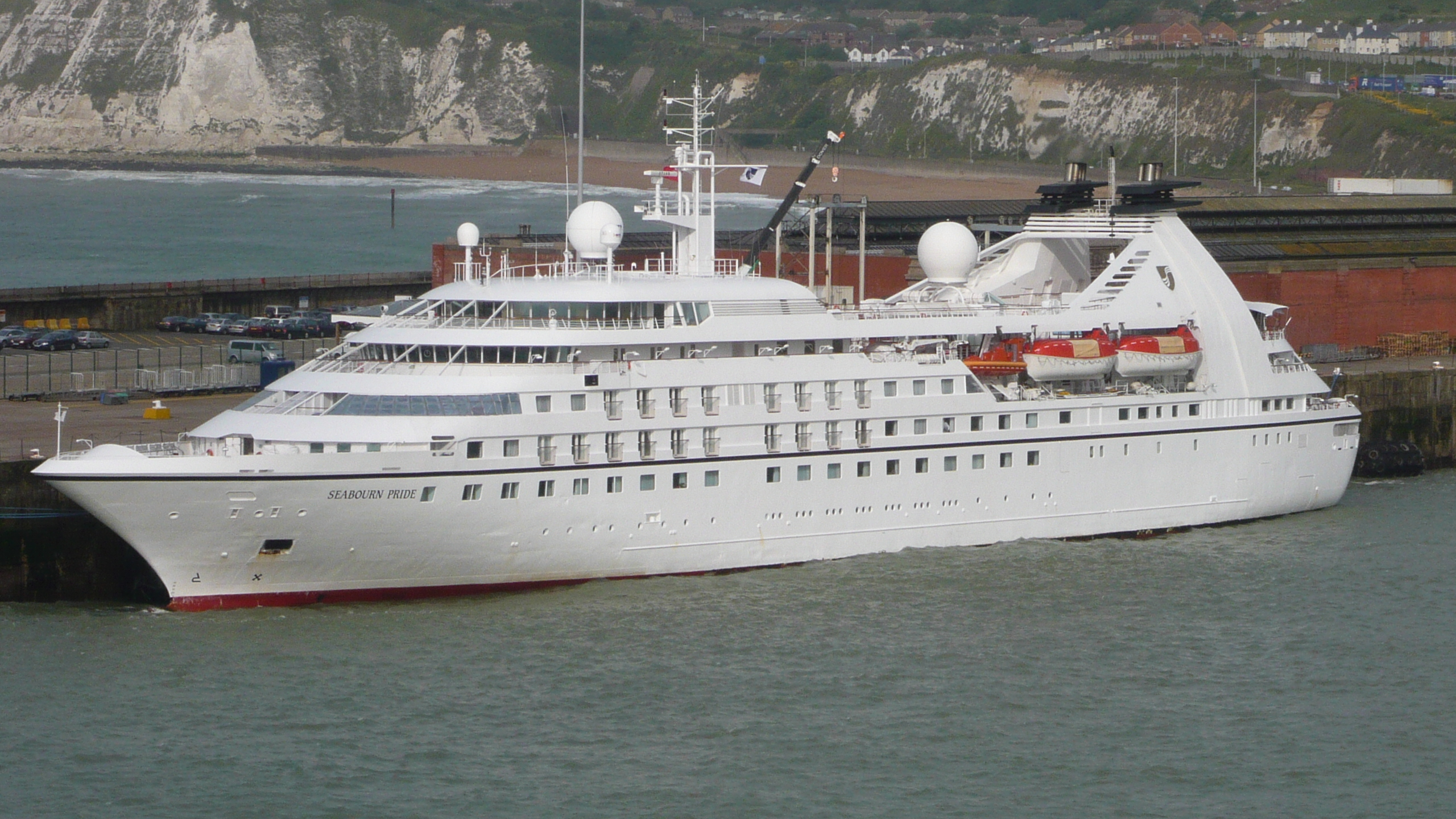 a large white cruise ship docked at the port