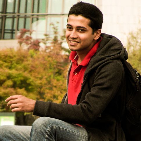 a smiling man with a red shirt and a backpack