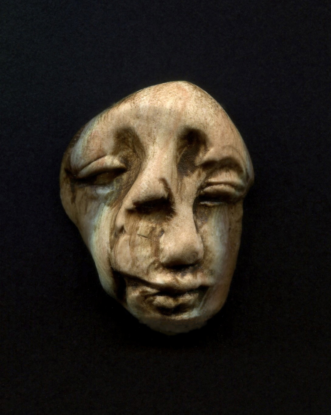 a wooden mask hanging on a wall