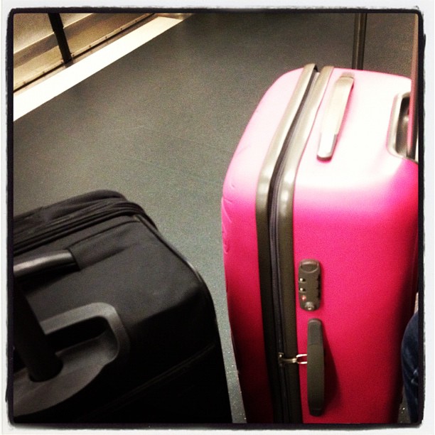 a close up of a pink suitcase and a black one