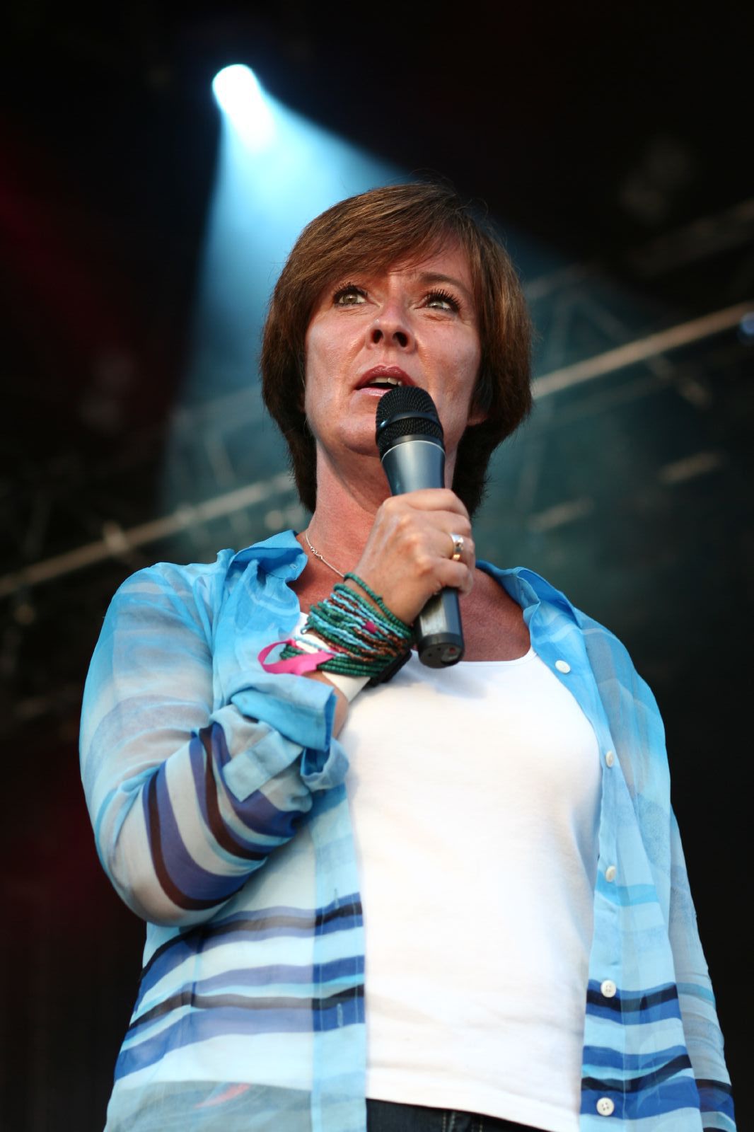 the woman is on stage with her hair sticking out and a microphone in her mouth