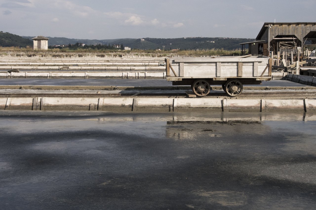 a flatbed dump truck in front of a abandoned water treatment