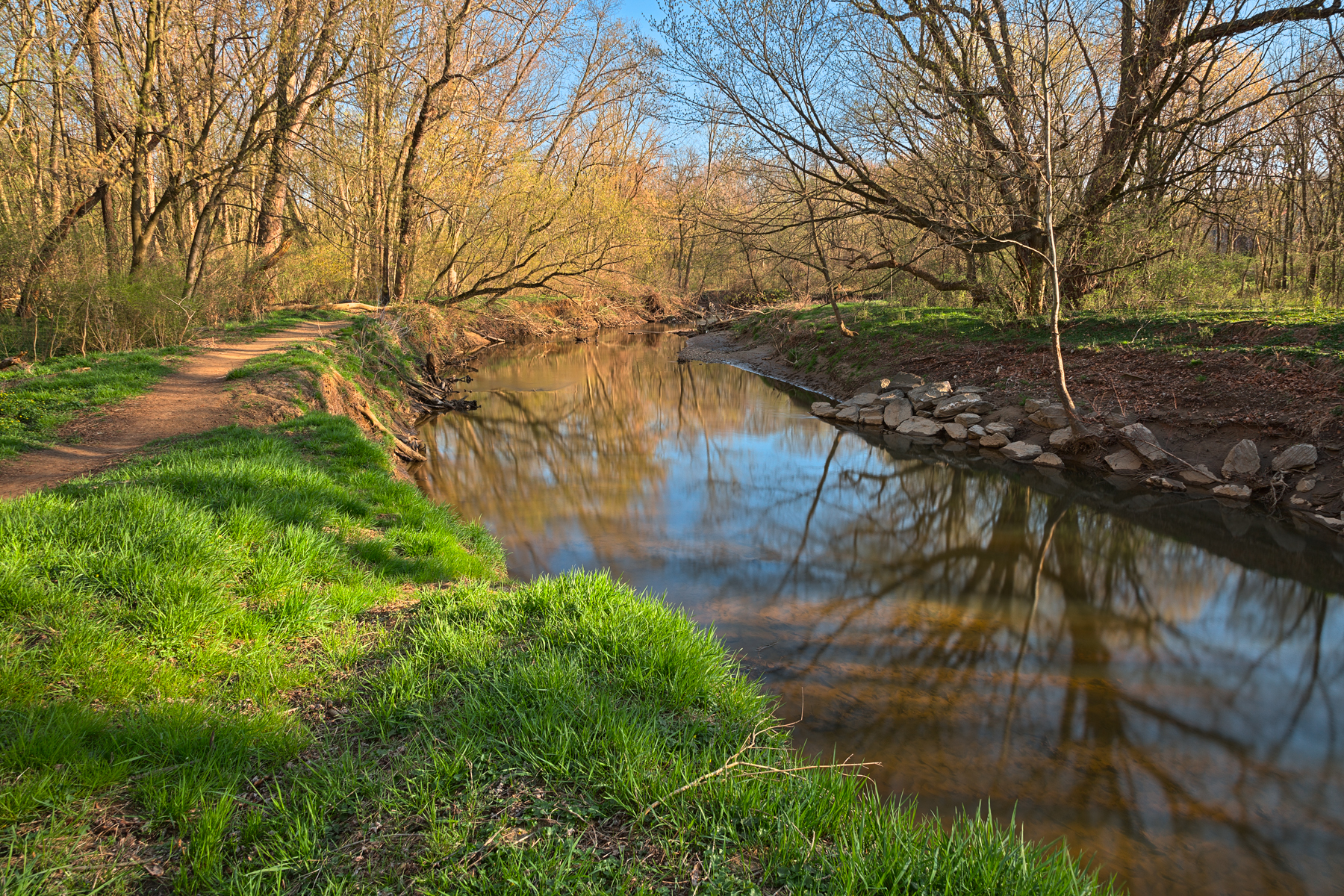a river is seen surrounded by green grass