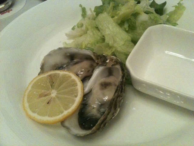 there is a plate full of clams and a lemon wedge