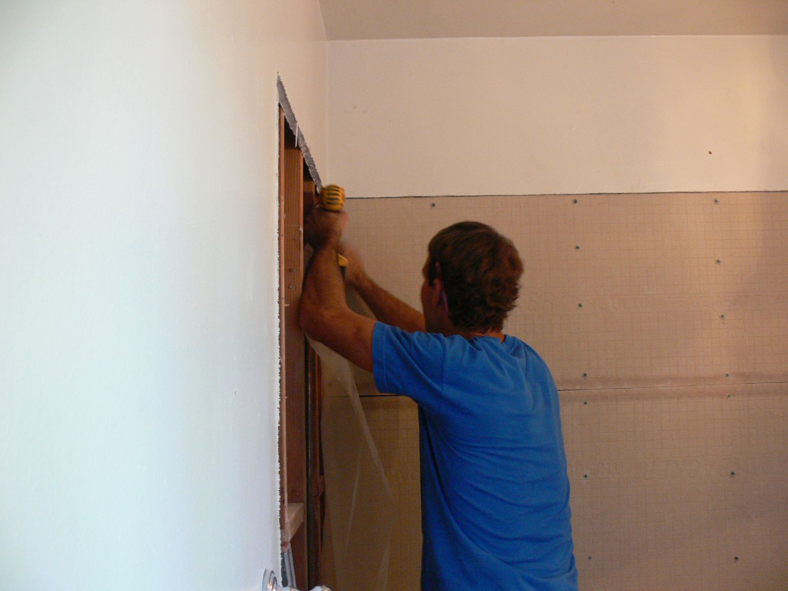 a man is using a hammer to install a wall