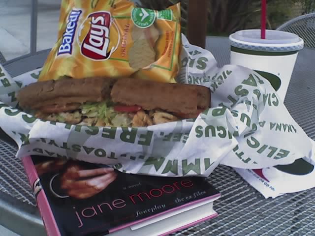 there is a sandwich and book on the table