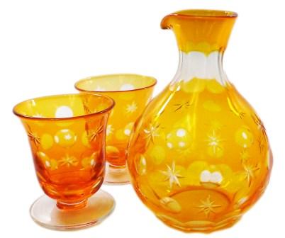 orange glass pitcher and cups sitting next to each other