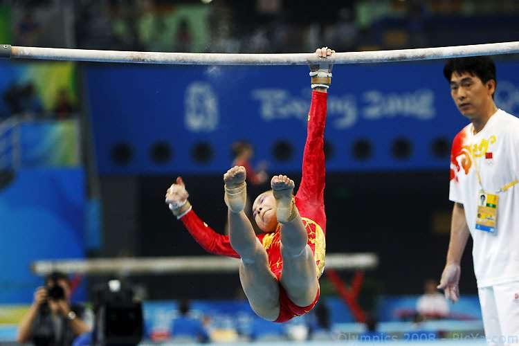 a man performing a high bar routine on the ground