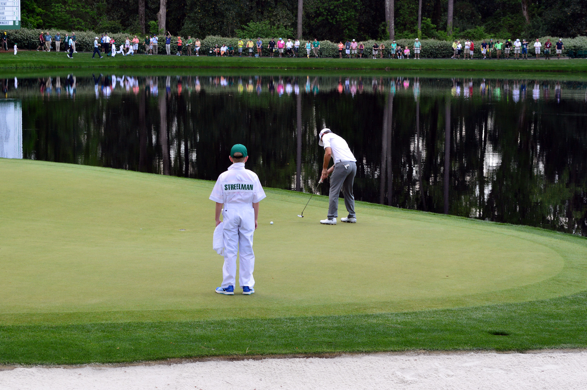 two players are standing on a course with their clubs