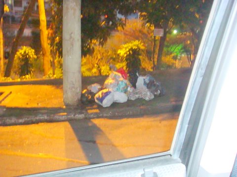 garbage is piled up in the street beside a bus