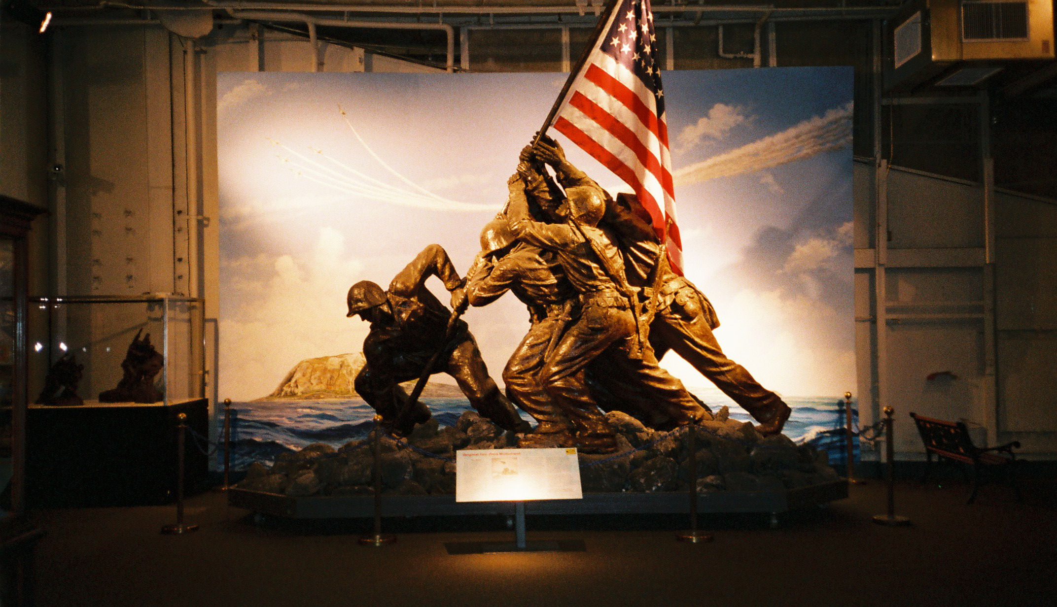 a large statue in front of a flag display