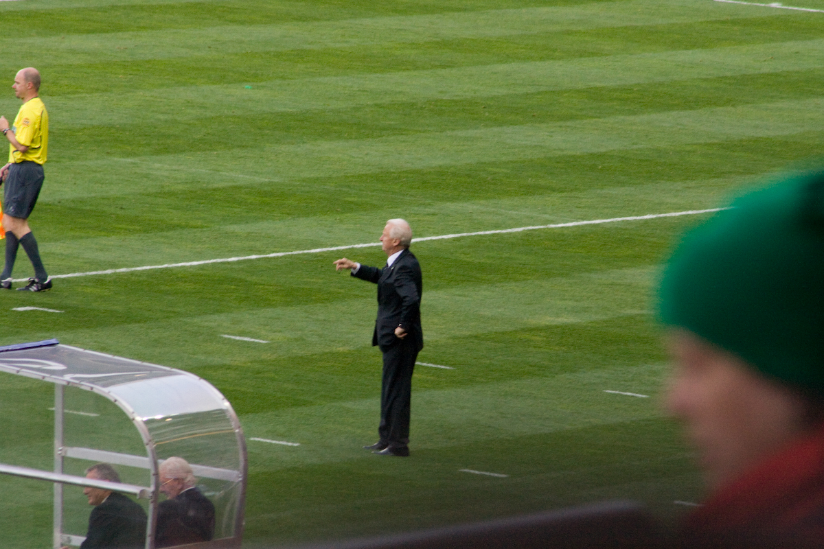 two men on a field in suits and green caps