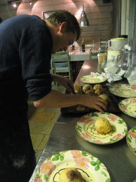 a man with a black shirt is preparing plates and food