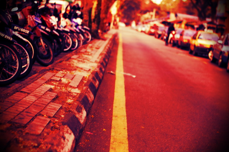 a long line of parked motor bikes lined up along a city street