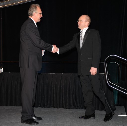 two men shake hands at an event