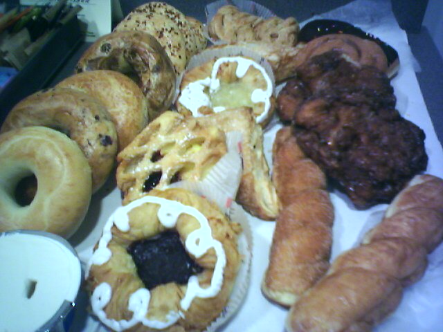 several pastries sit on a table along with a candle