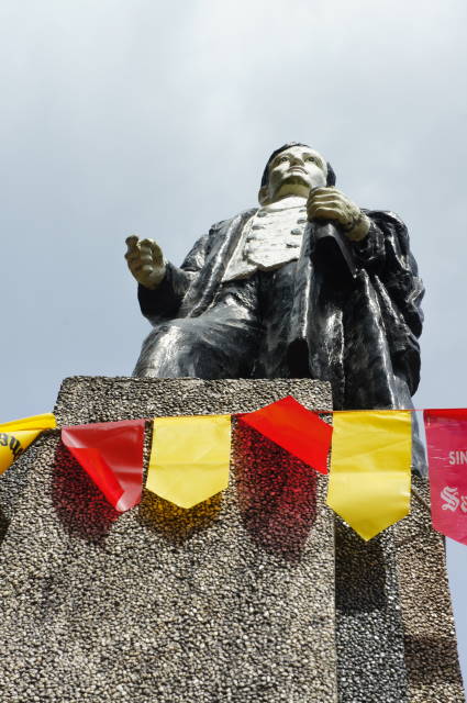 there is a statue with a man wearing a jacket with a scarf on it