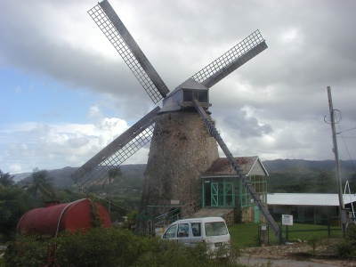 an old windmill and a white van parked by it