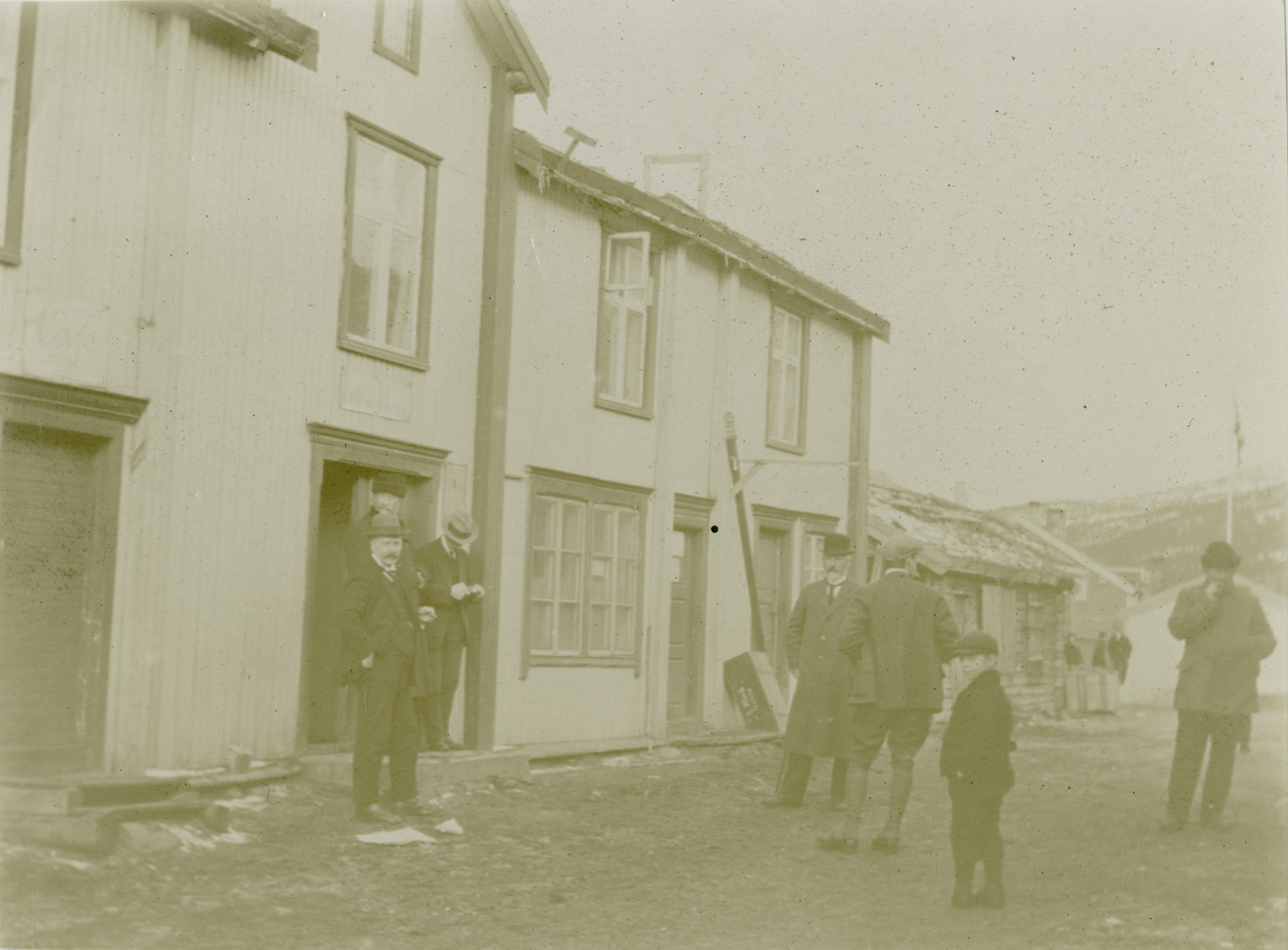 a black and white po of people outside of a house