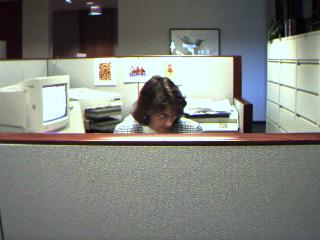an office cubicle with a person in the reflection