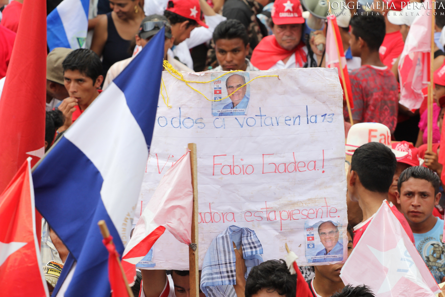 a group of people carrying a poster with an image of cuban president