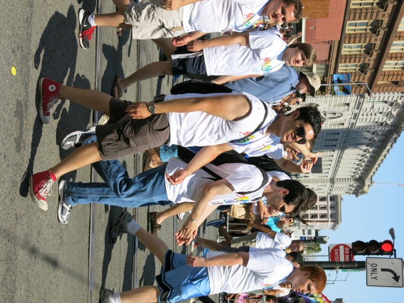 young people are walking through a parade in the street