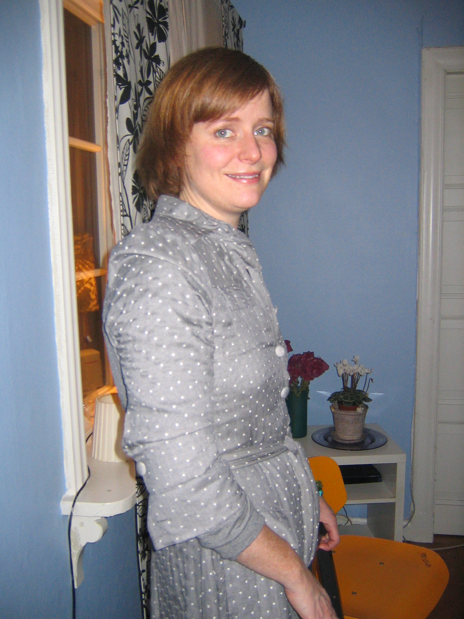 a woman in a polka dotted dress in a blue room