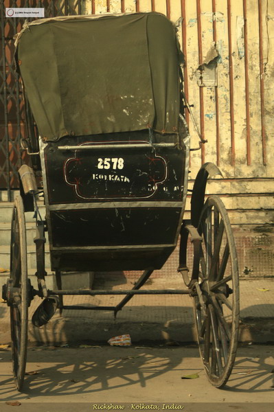 an old horse drawn carriage parked on the side of the road