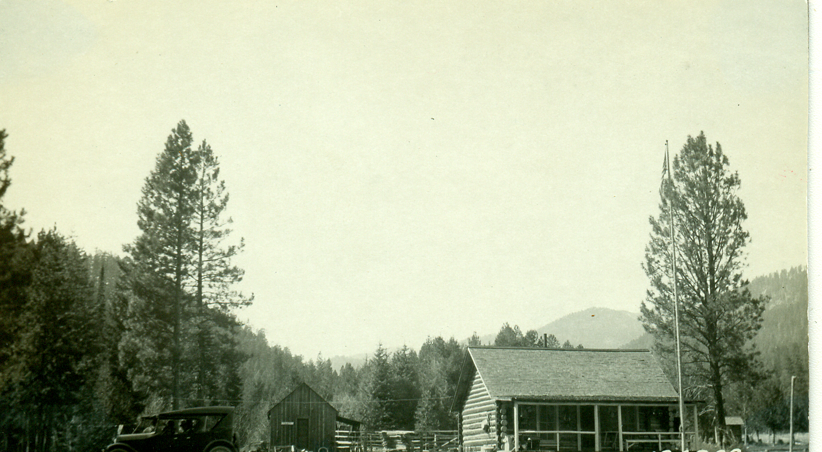 a black and white po of people standing outside a cabin