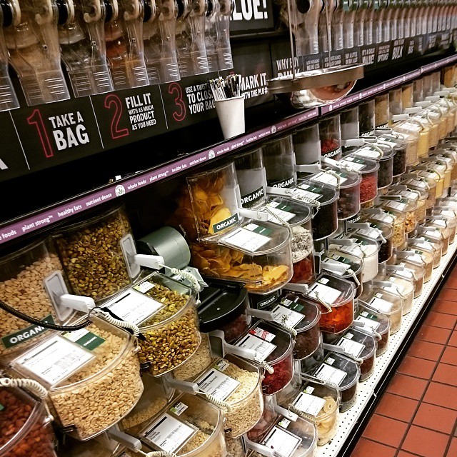 a produce section of a store with jars and containers of various foods
