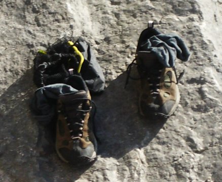 two hiking shoes with clothes laid on top of them