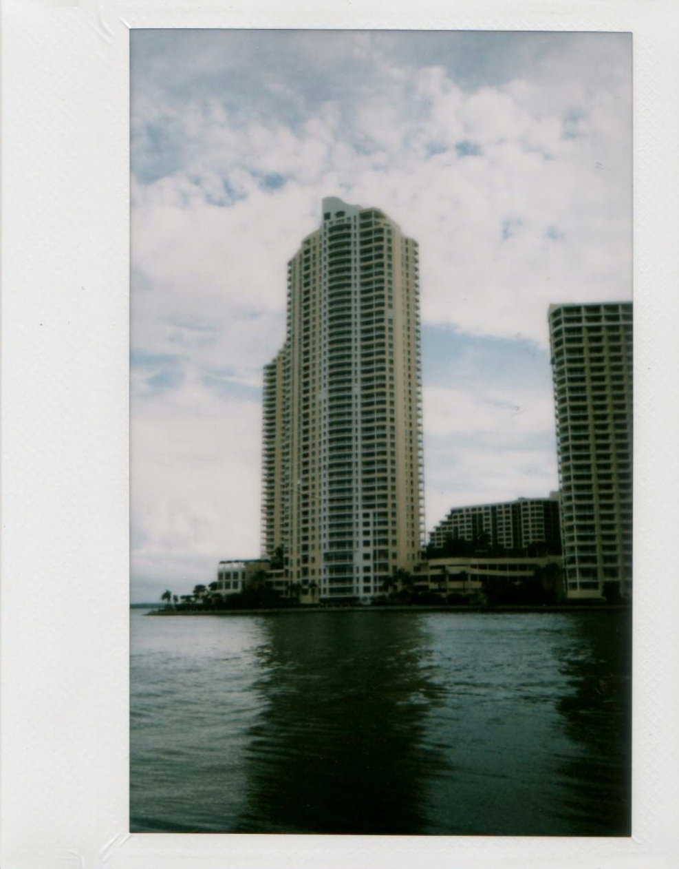 two buildings sit on a waterfront near the water