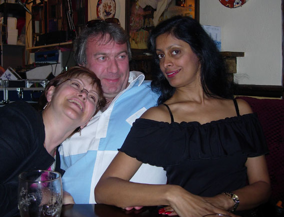 a man and two women smile while at a table
