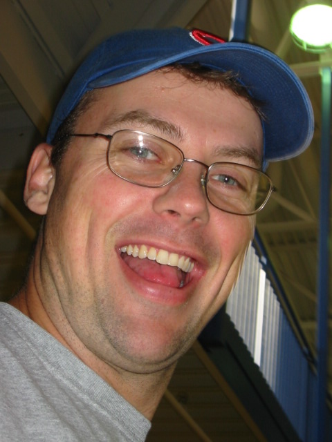 a man with glasses and hat in an indoor area