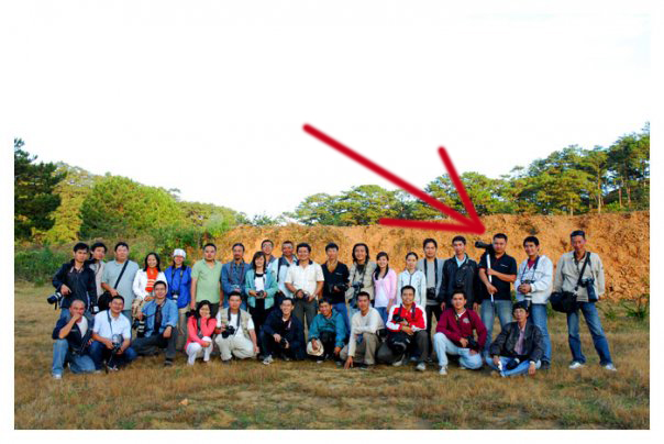the group of tourists are posing for a picture with a red arrow pointing toward them