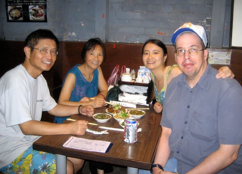 a group of friends sitting at a restaurant eating food