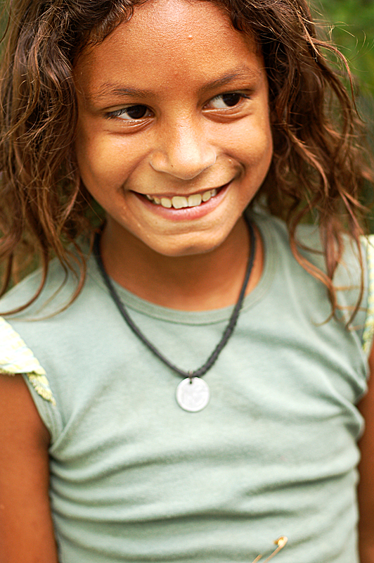 a  with long dark hair, wearing a green shirt and smiling for the camera