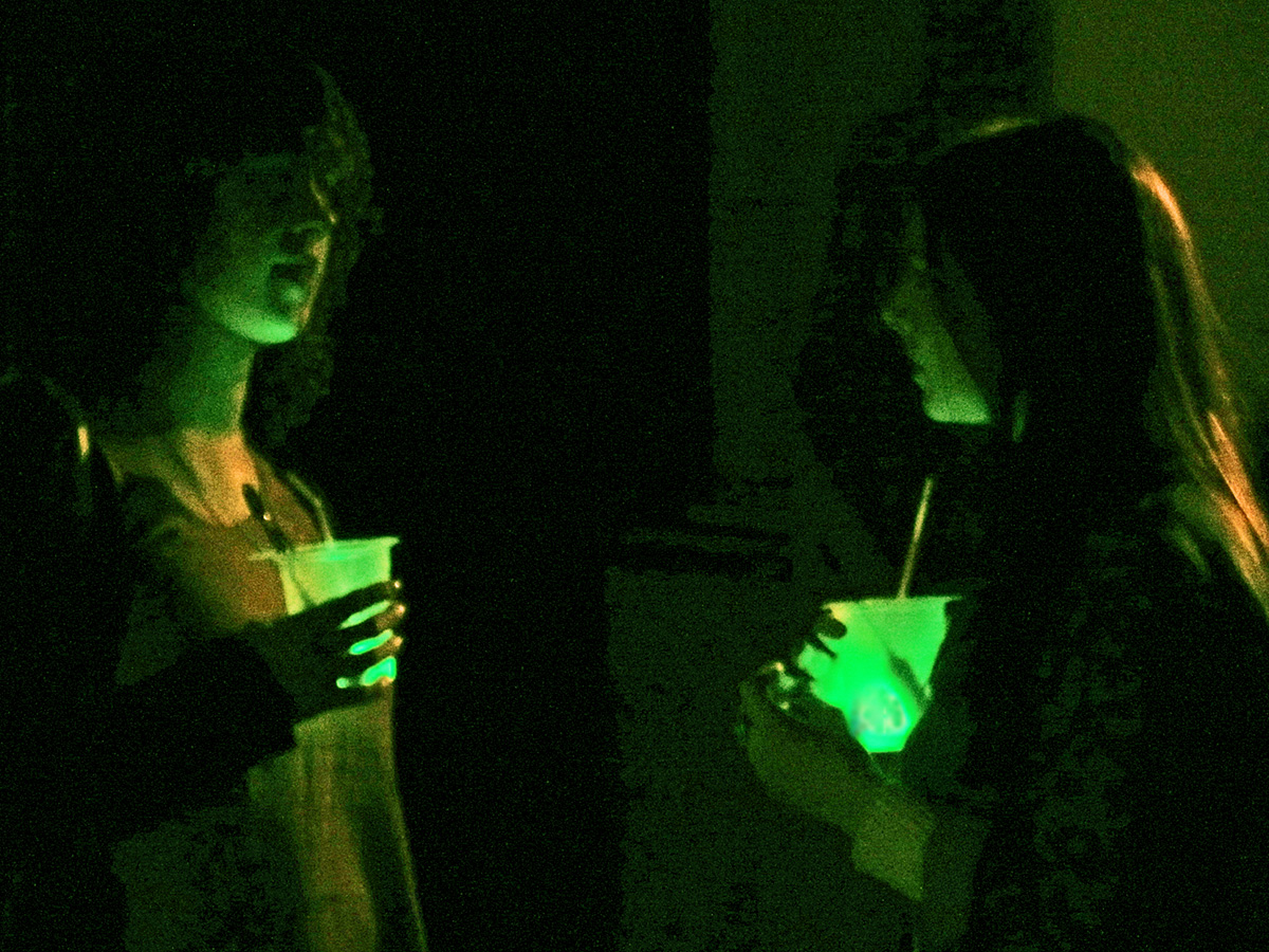 two young women looking at the light from their cell phones