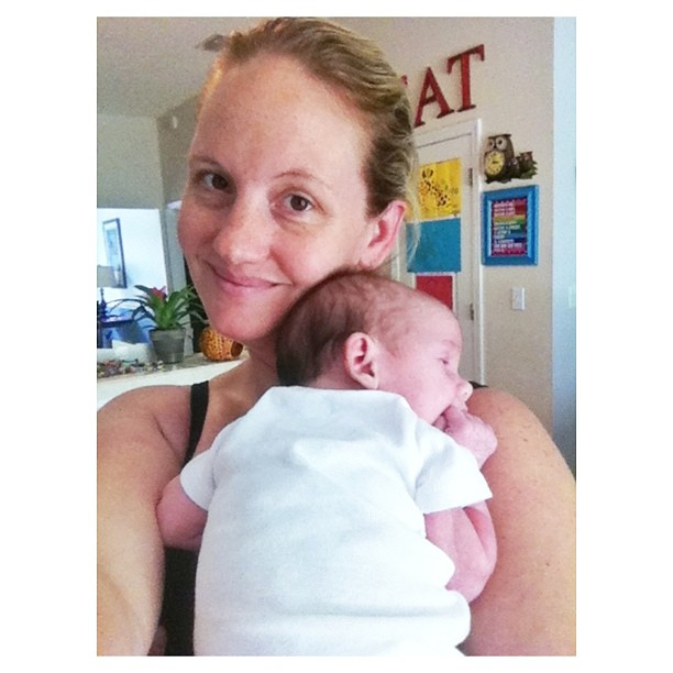 a woman holding a baby and smiling at the camera