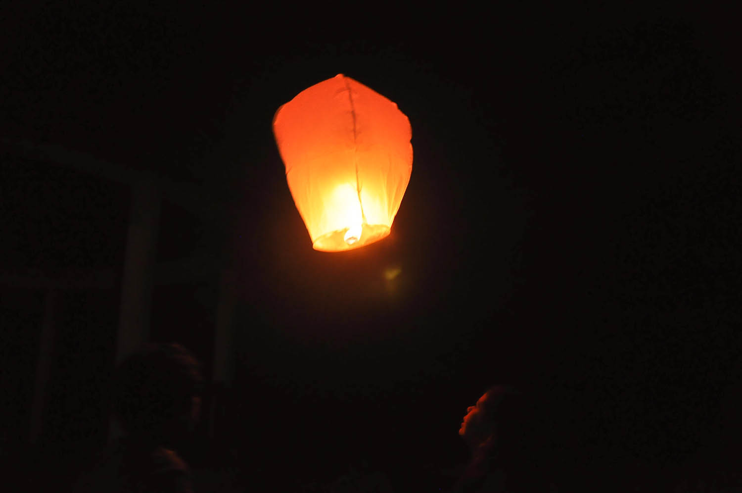 a lit lantern sitting on top of a dark night