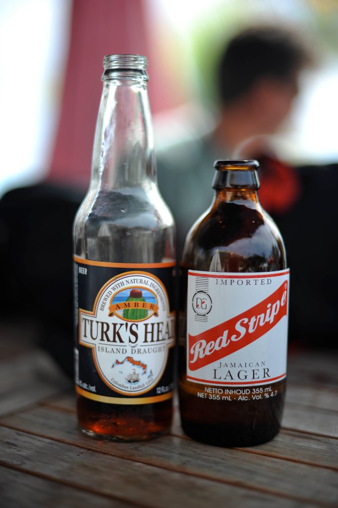 two bottle styles of beer sit on a table