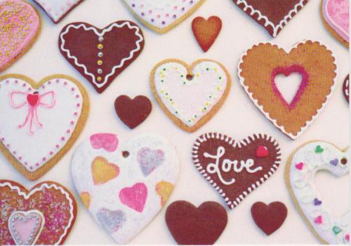 a variety of heart shaped cookies on a white surface