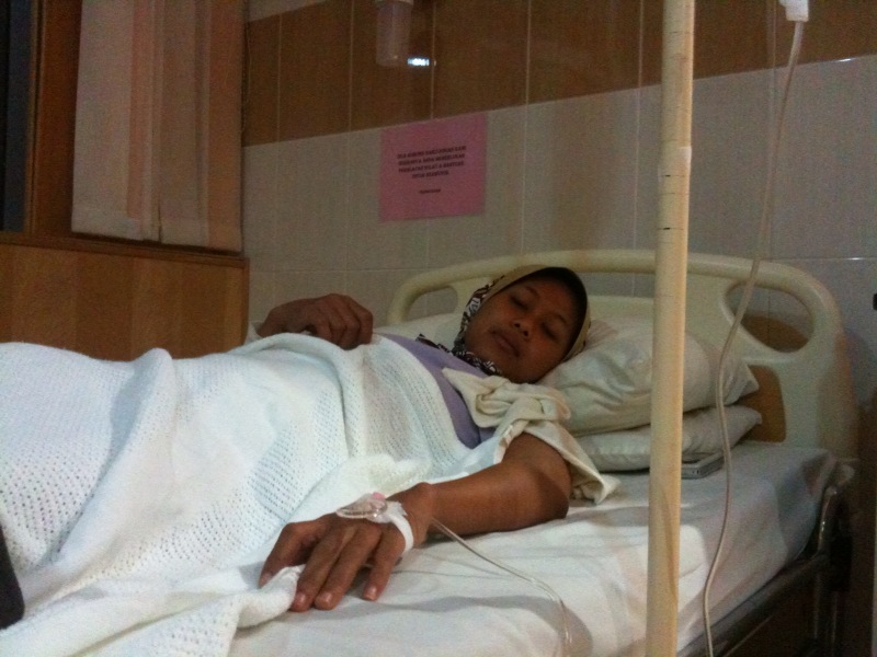 a young woman is lying in a hospital bed