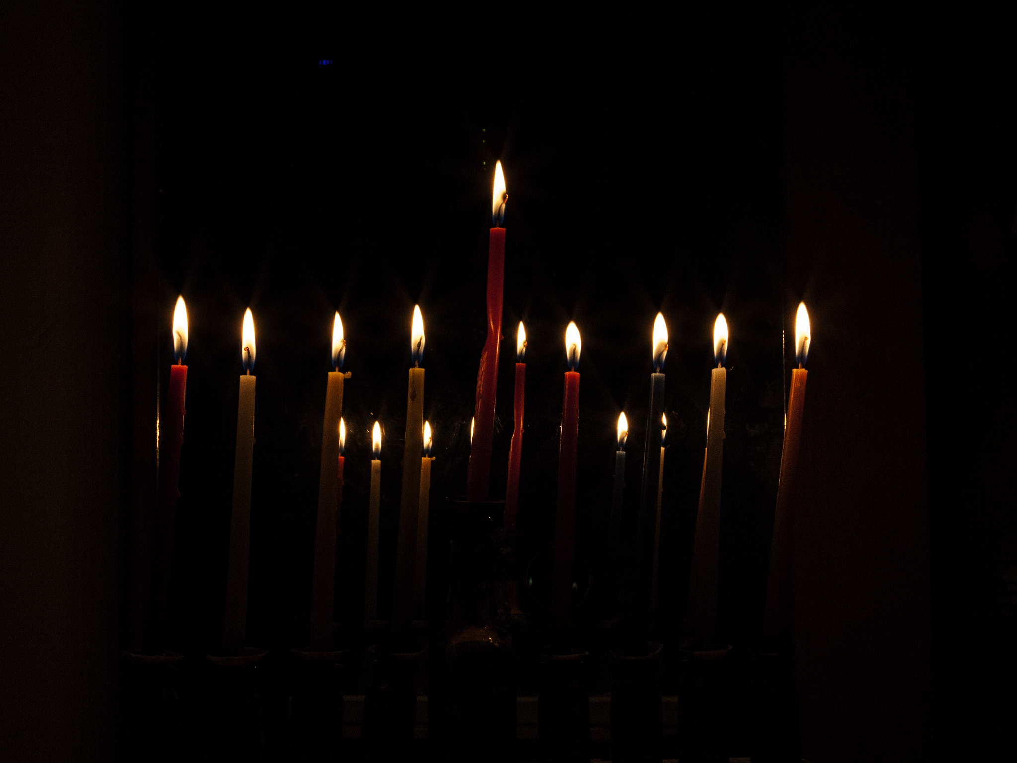 a candle with many candles lite in the dark