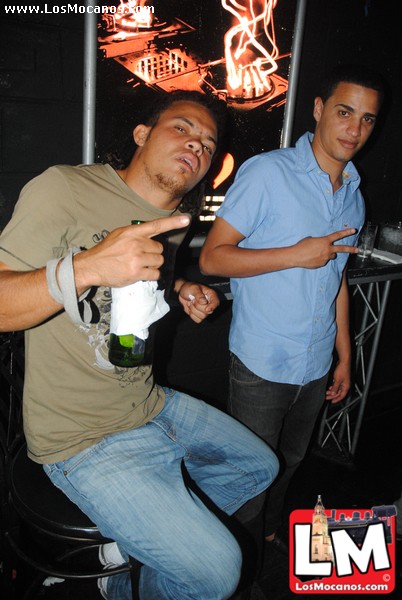 two men in a club one pointing to the camera