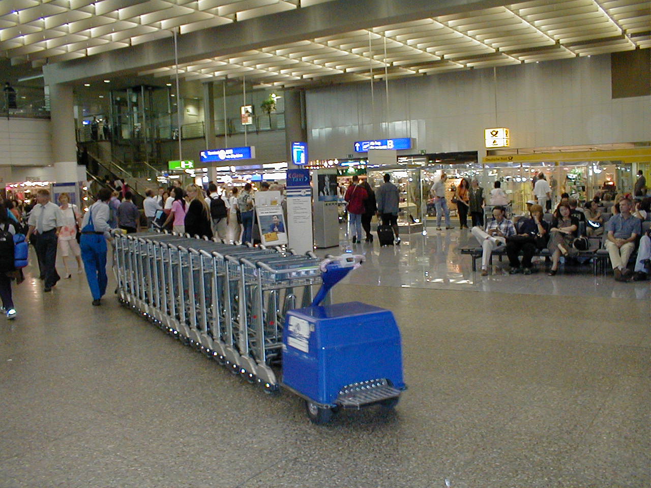 a luggage cart sits idle in a crowded terminal