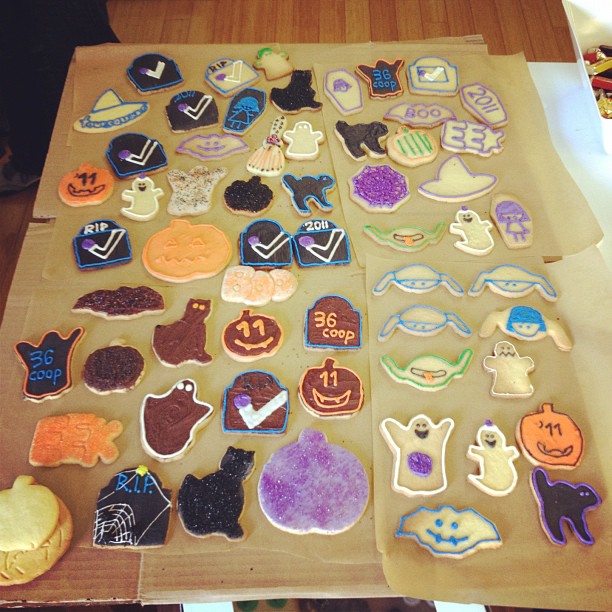 a table covered in halloween decorated cookies next to a brown bag