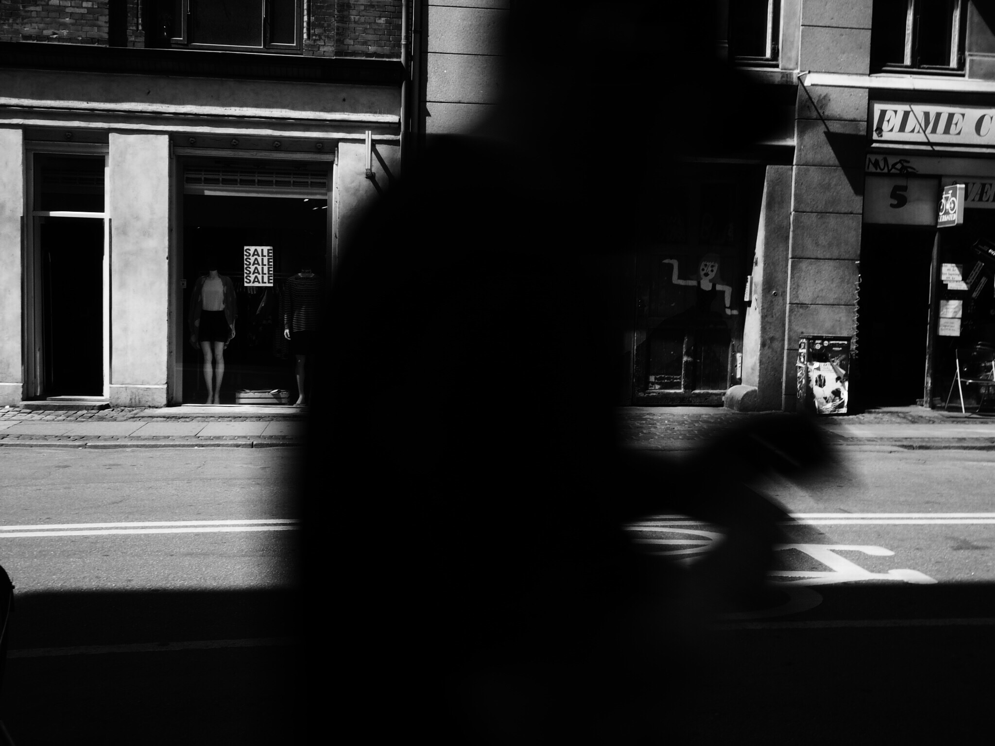 the shadow of a motor bike rider in the foreground on the corner