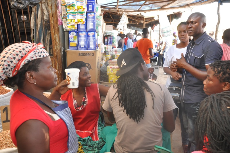 a group of people standing around talking and drinking